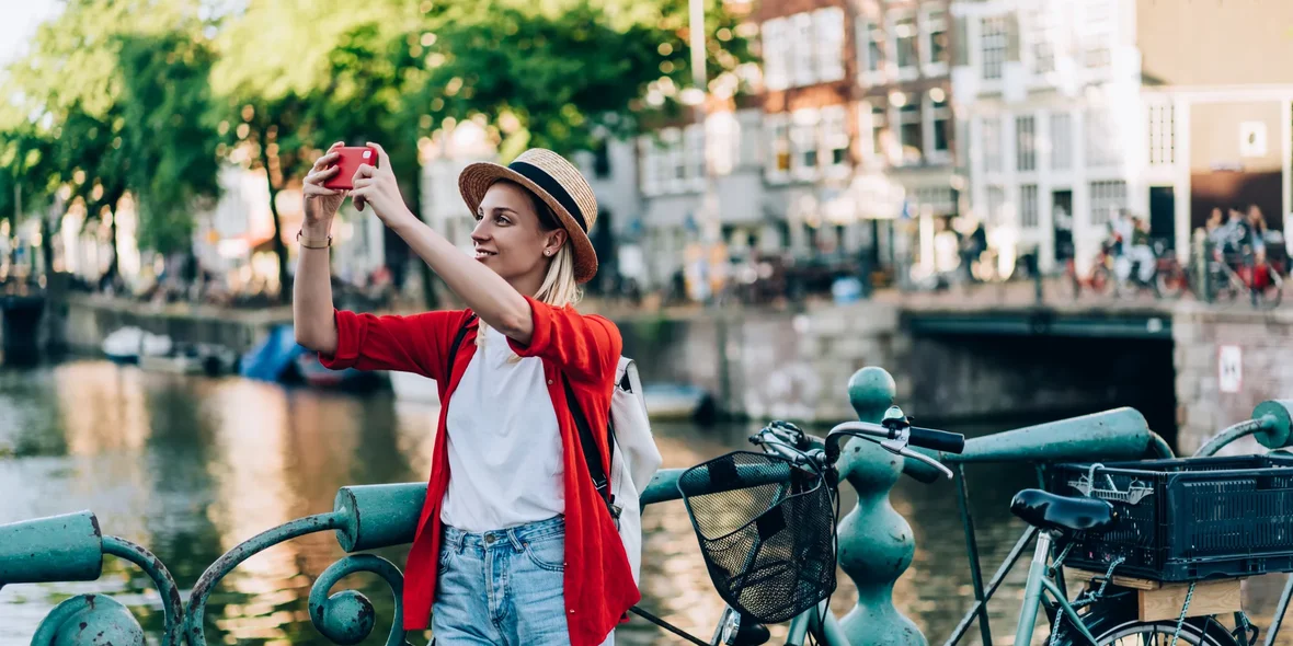 A girl taking pictures of something in Amsterdam.