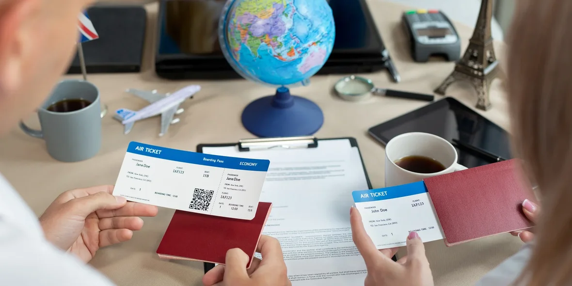 A close-up of passports and tickets in the hands of travelers at a travel agency