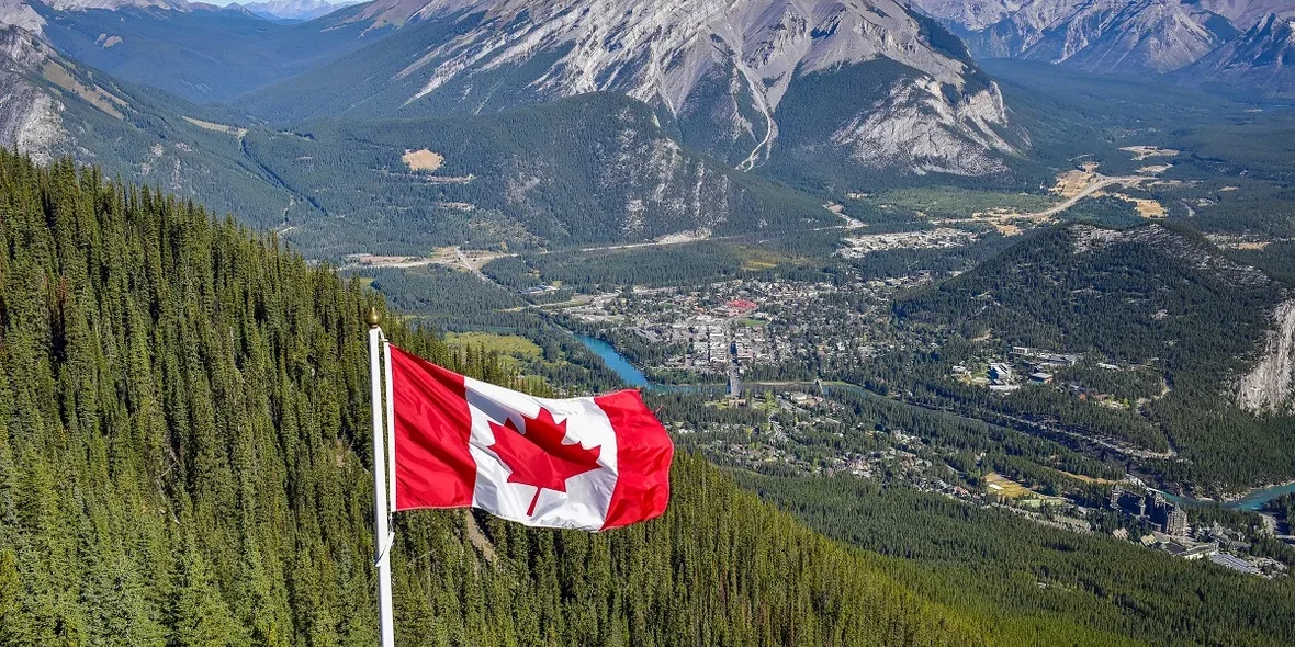 Canada's flag against the backdrop of the Canadian Rocky Mountains