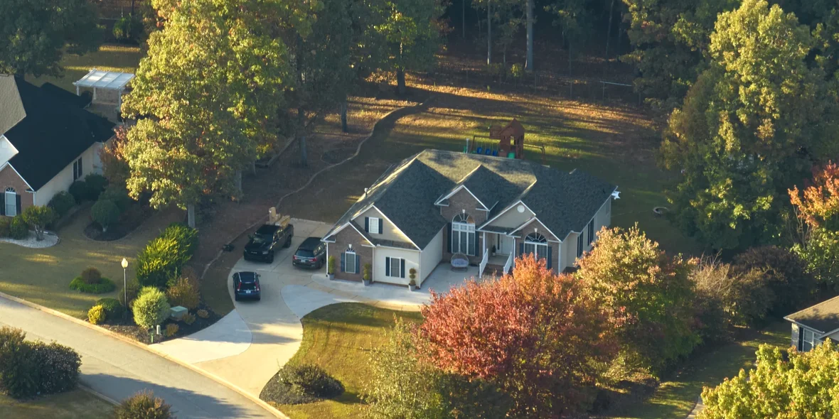 Aerial view of new family home among yellow trees in suburban South Carolina