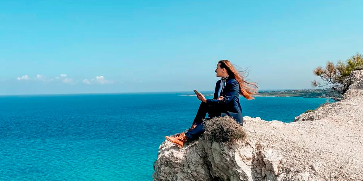 girl are sitting on a cliff and looking at the sea