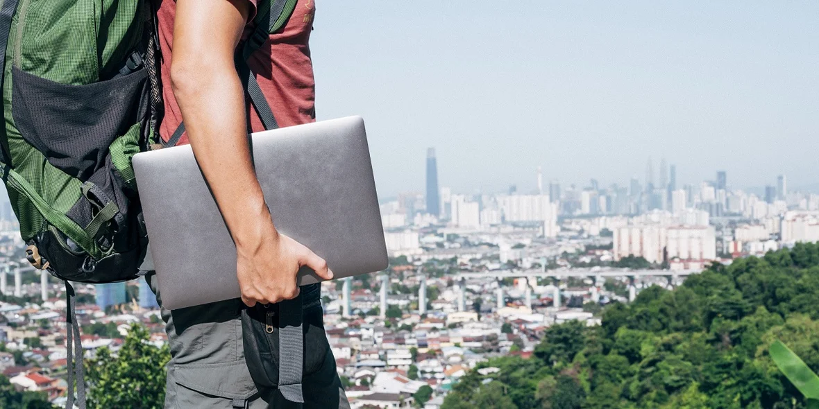 A digital nomad walks around with a laptop in his hands