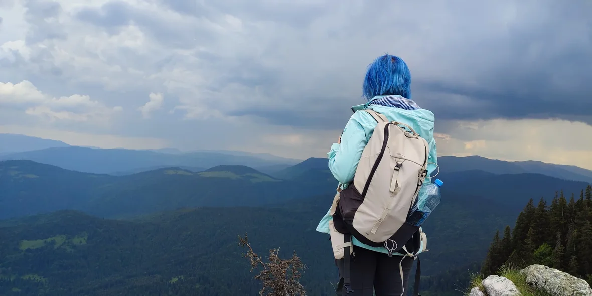 A girl with a backpack in the mountains of Romania
