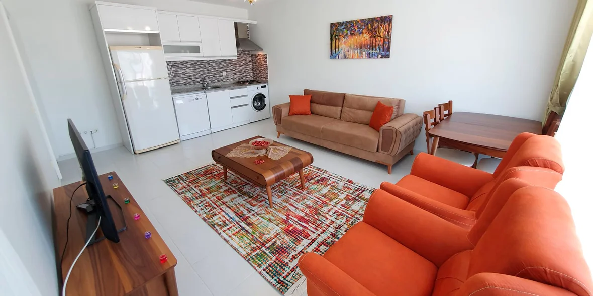 Orange armchairs and bright carpet in the living room