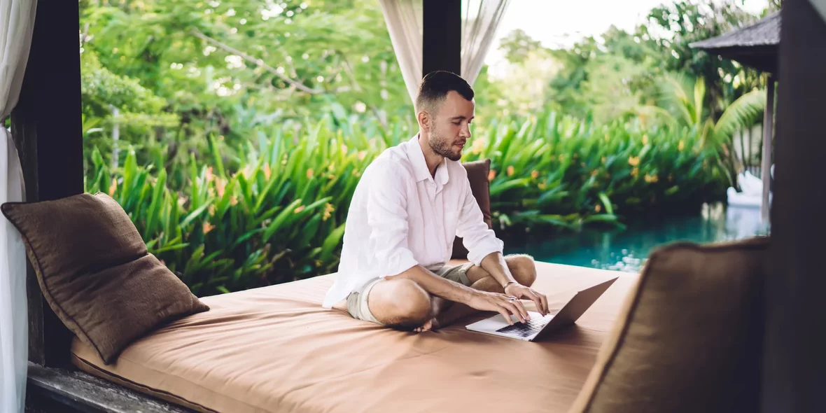 A digital nomad behind a laptop in a beautiful entourage