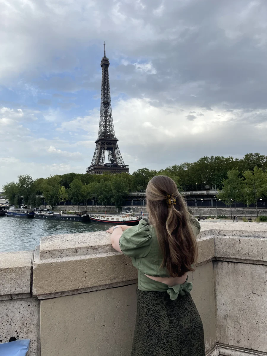 A girl looking up at the Eiffel Tower.