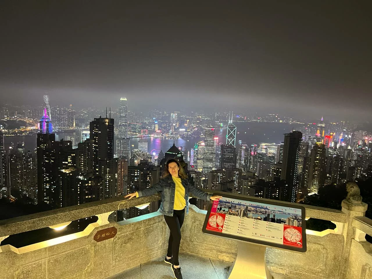 A woman on an observation deck in Hong Kong, night view from above