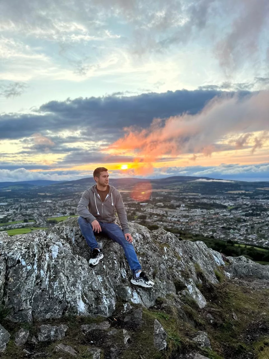 Станислав сидит на склоне горы