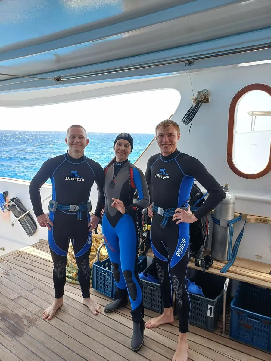 a woman and two men prepare to dive in the Red Sea