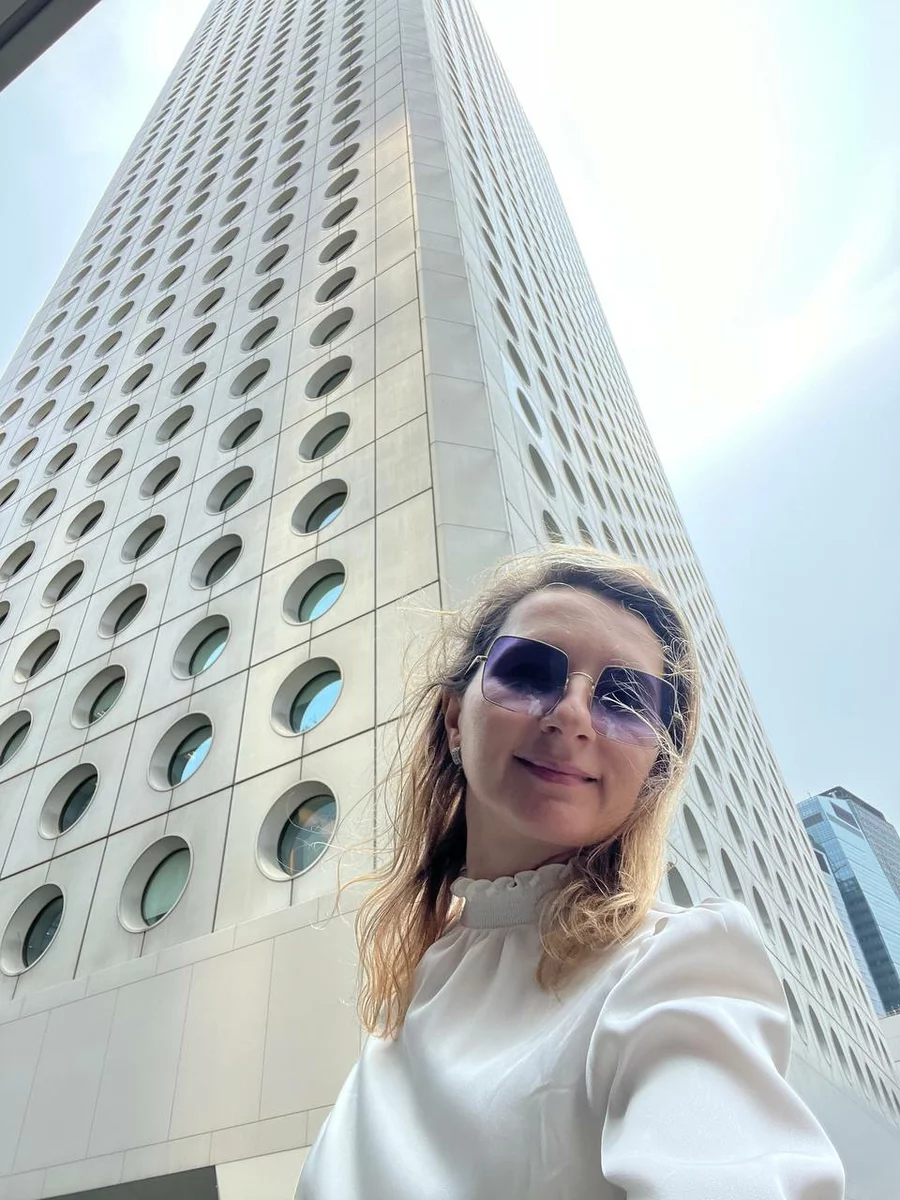 A woman in front of a high-rise building