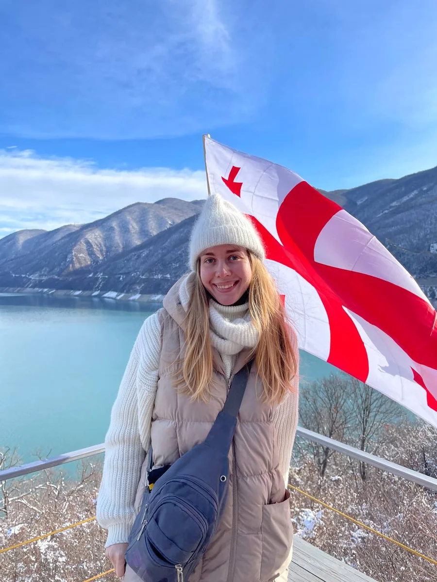 smiling girl against the mountains and the flag