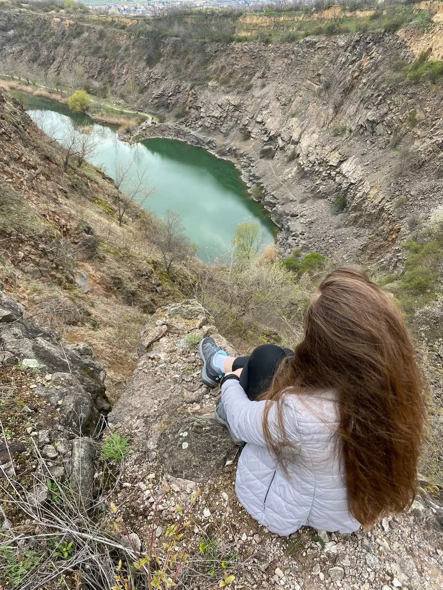 Christina sits by the lake and rocks