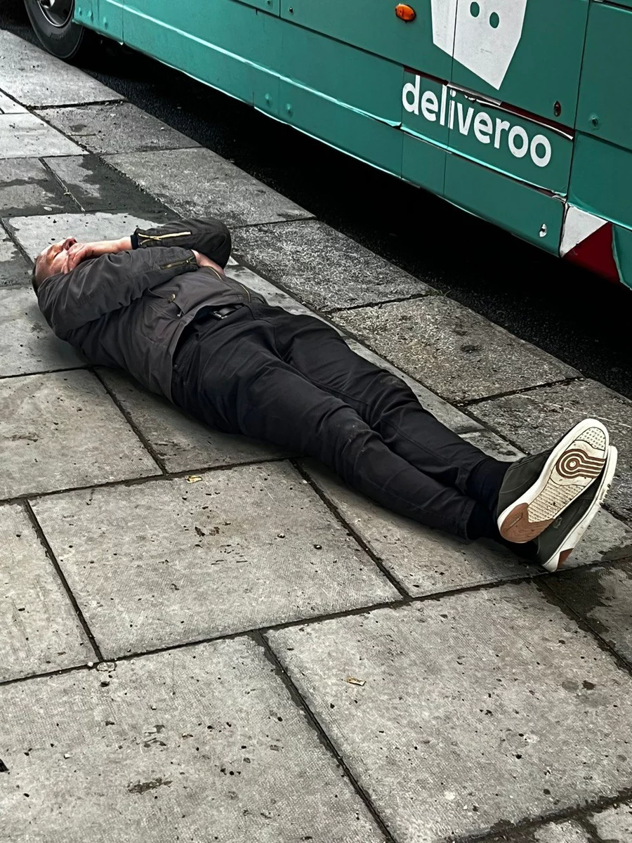 Пьяный мужчина, лежащий на дороге в Дублине
